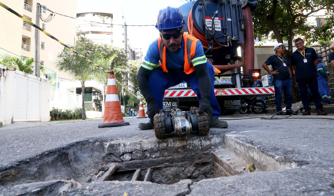 técnico da Seuma segura o robô pluvi antes de colocar em uma galeria pluvial